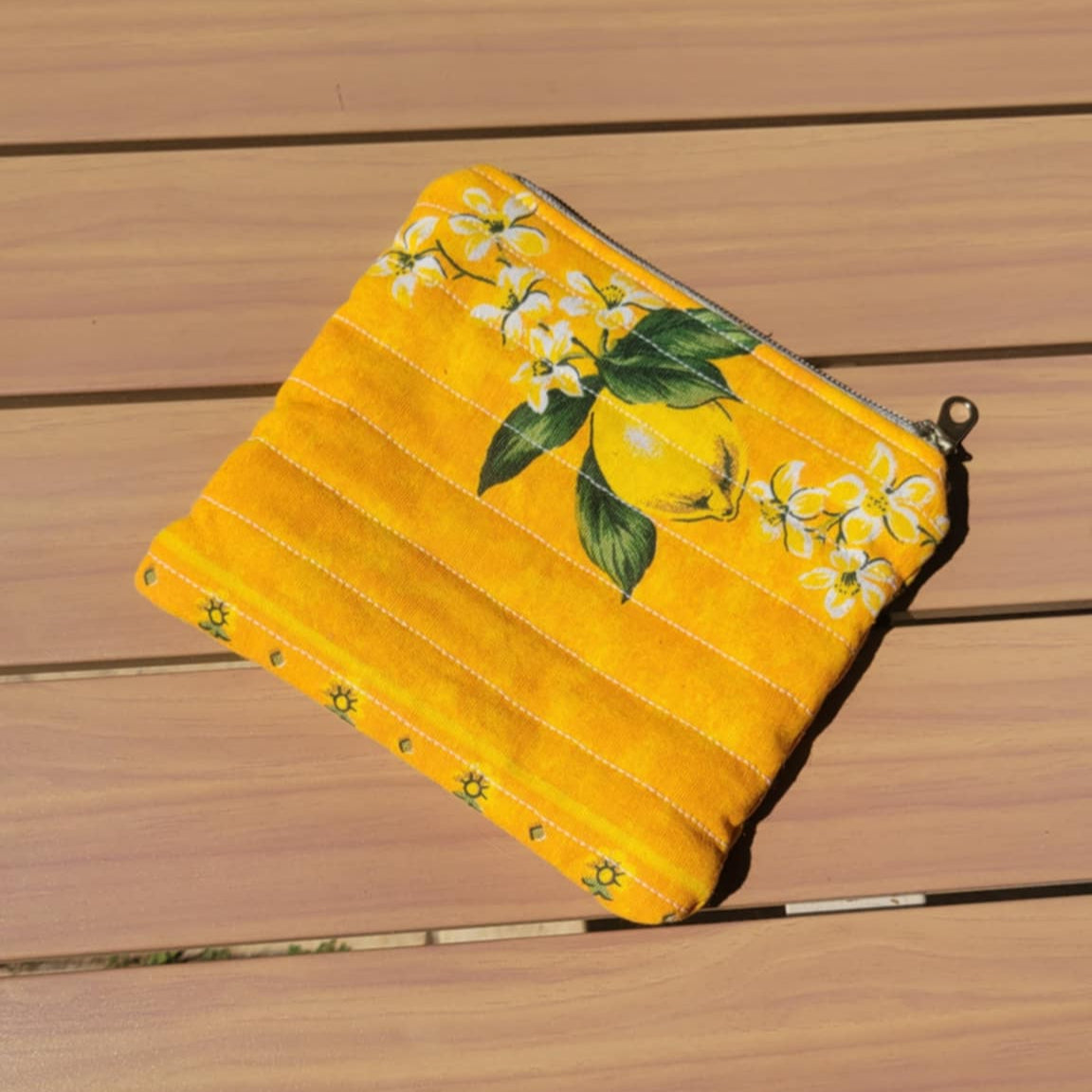 Yellow potholder with lemon design on a wooden surface