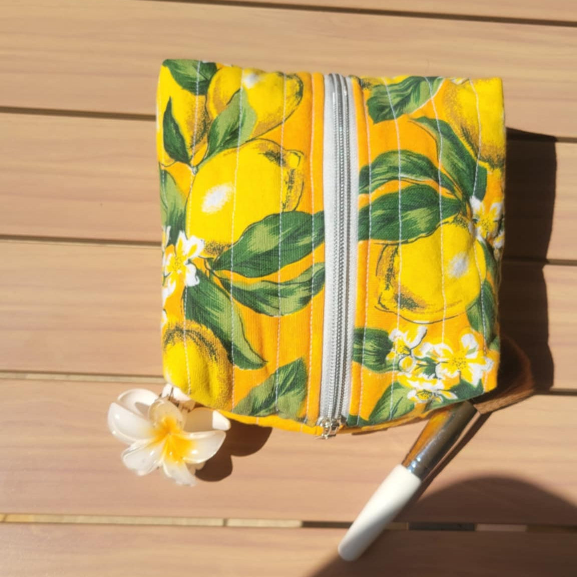 Yellow pouch with lemon pattern on a wooden surface