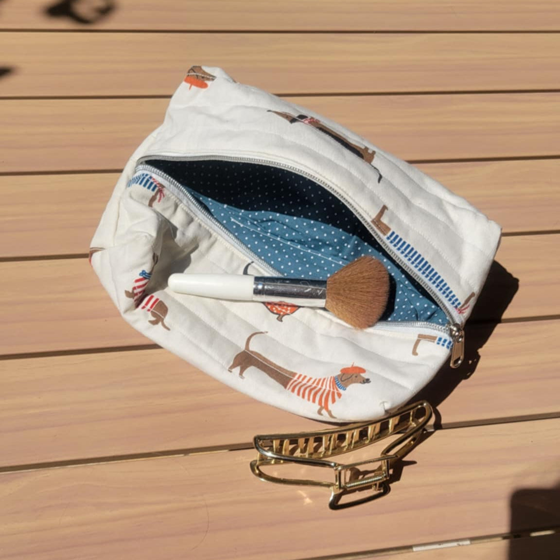 Makeup bag with brushes on a wooden surface