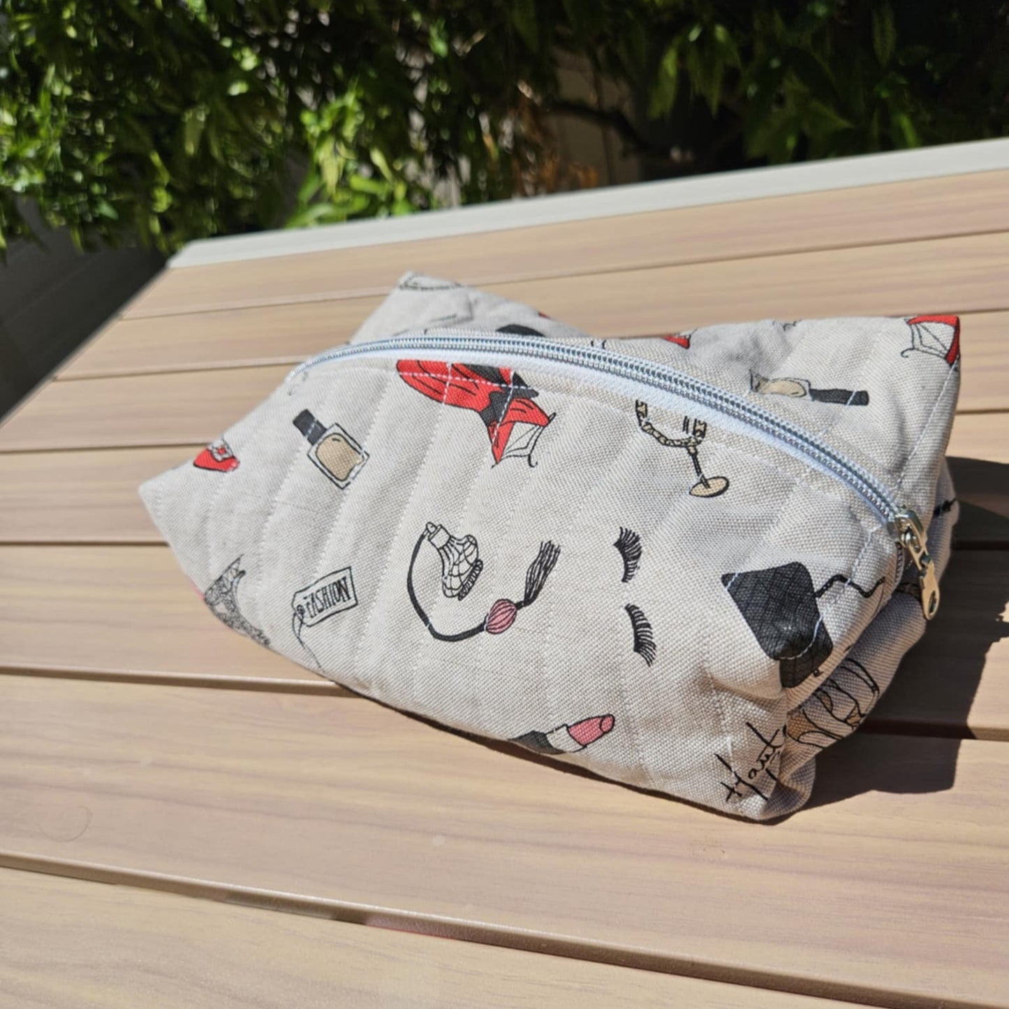 Fabric pouch with cartoon designs on a wooden surface