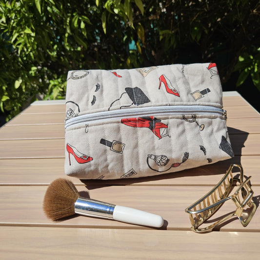 Makeup bag with cosmetic items on a wooden surface outdoors