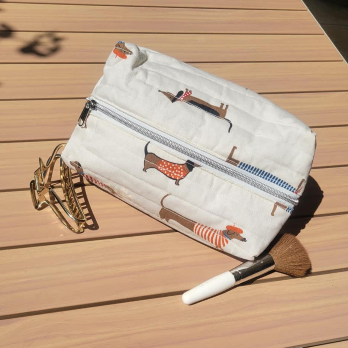 White pouch with dog illustrations on a wooden surface