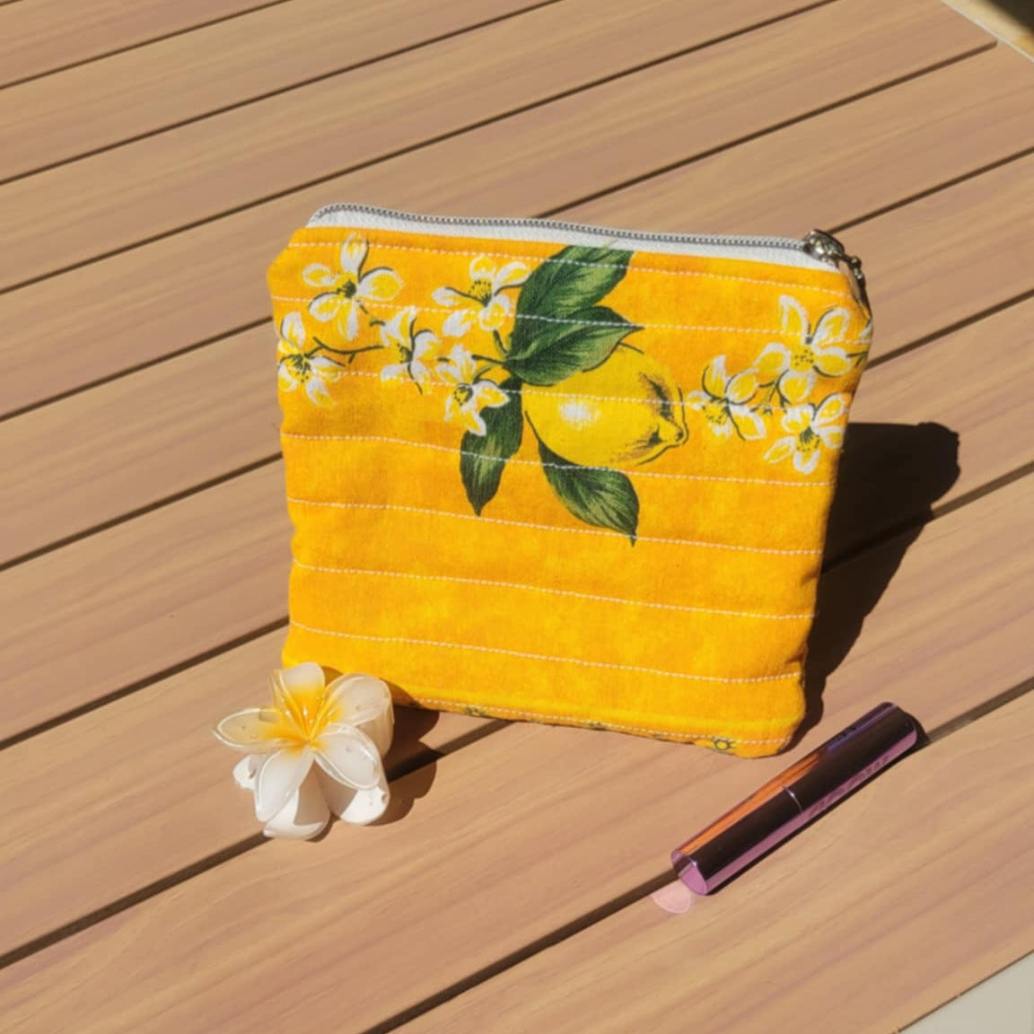 Yellow pouch with floral design on a wooden surface