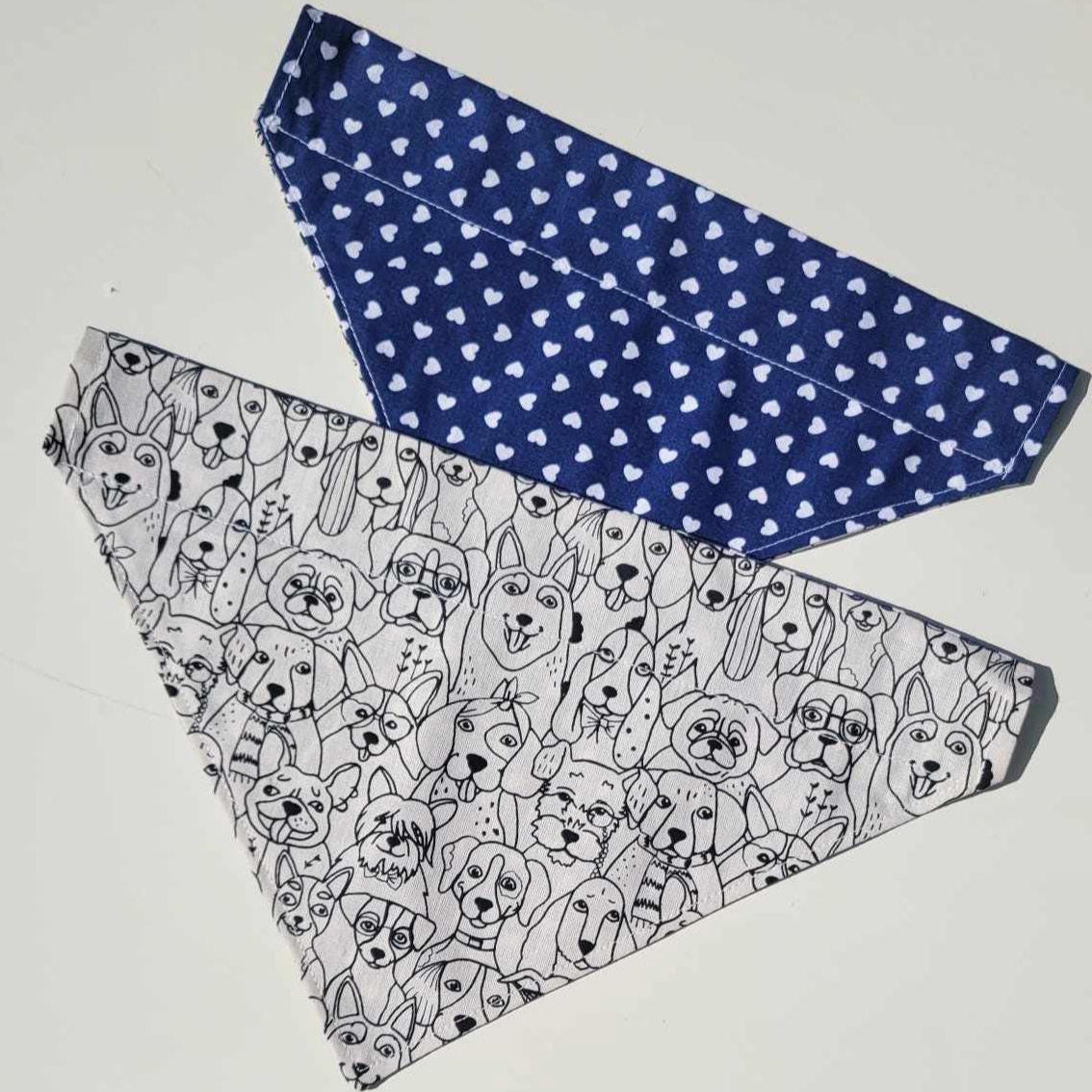 Handmade reversible dog bandana with a black and white dog face pattern on one side and navy with white hearts on the other. Slides onto collar. Available in small and medium.